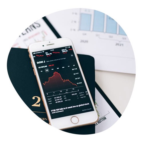 Photo of a Smartphone with the trend of the markets on the screen placed above the documentation and an agenda