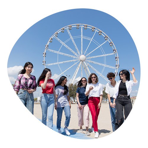Group of students walking with the Ferris wheel in Rimini