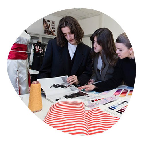 Female students analyzing tissues in a tailoring workshop