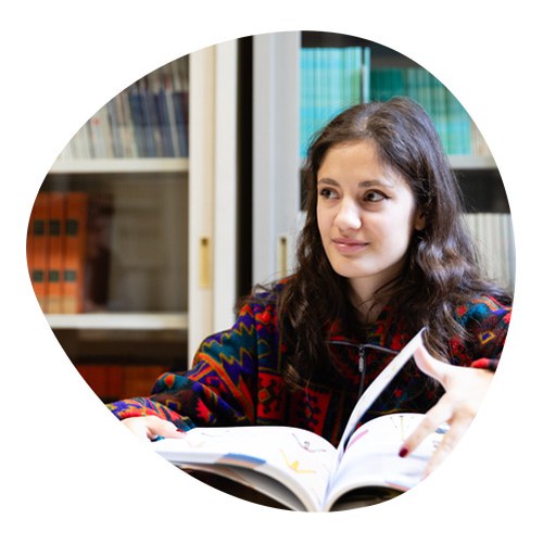Girl in library browsing pages of a large book