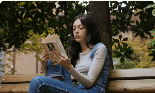 Student sitting on a bench reading