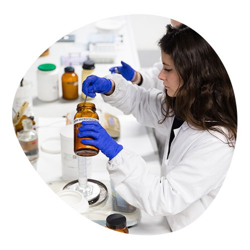 Researcher working in the laboratory on powdered products with a glass jar and test tubes